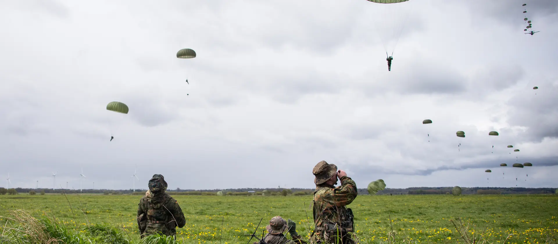 Fallschirmspringer der Fallschirmjägertruppe landen auf einer Wiese