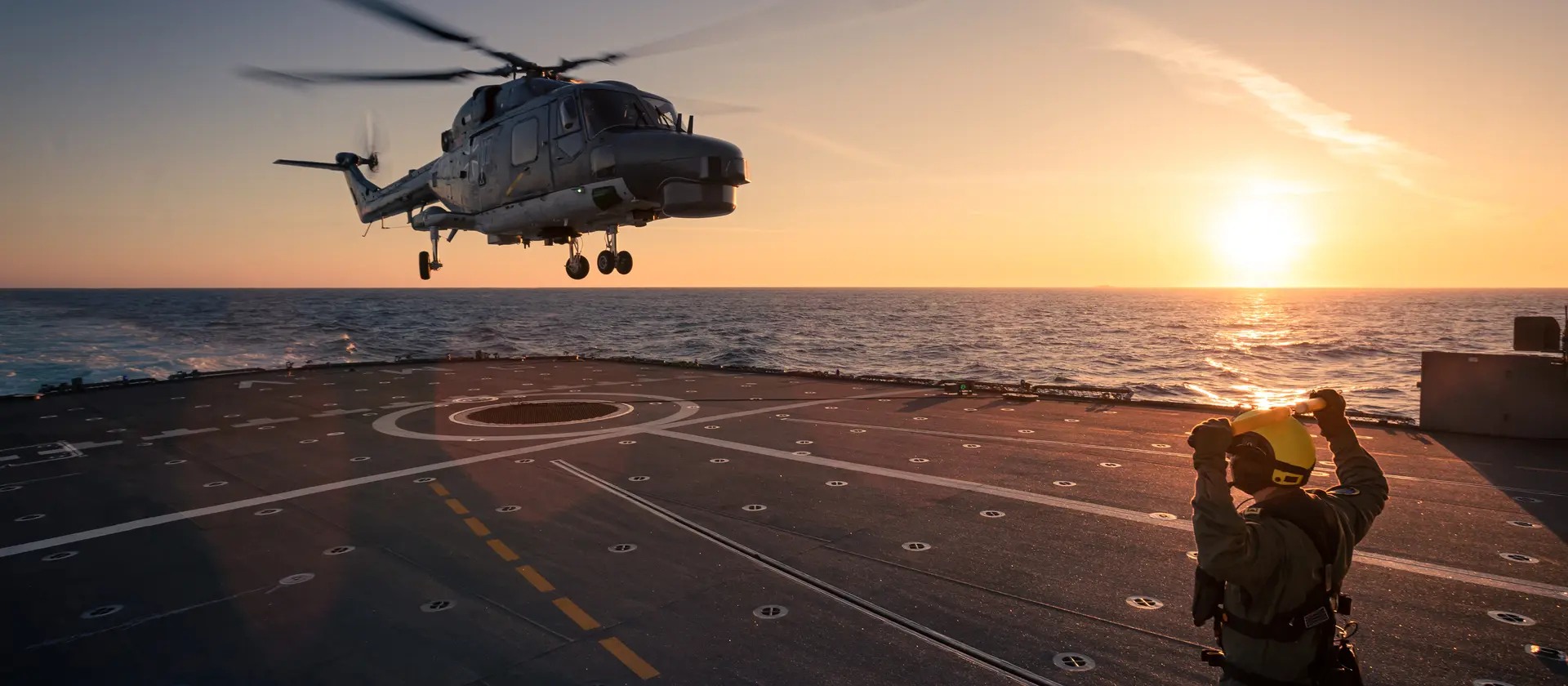 Ein Hubschrauber im Landeanflug auf eine Fregatte