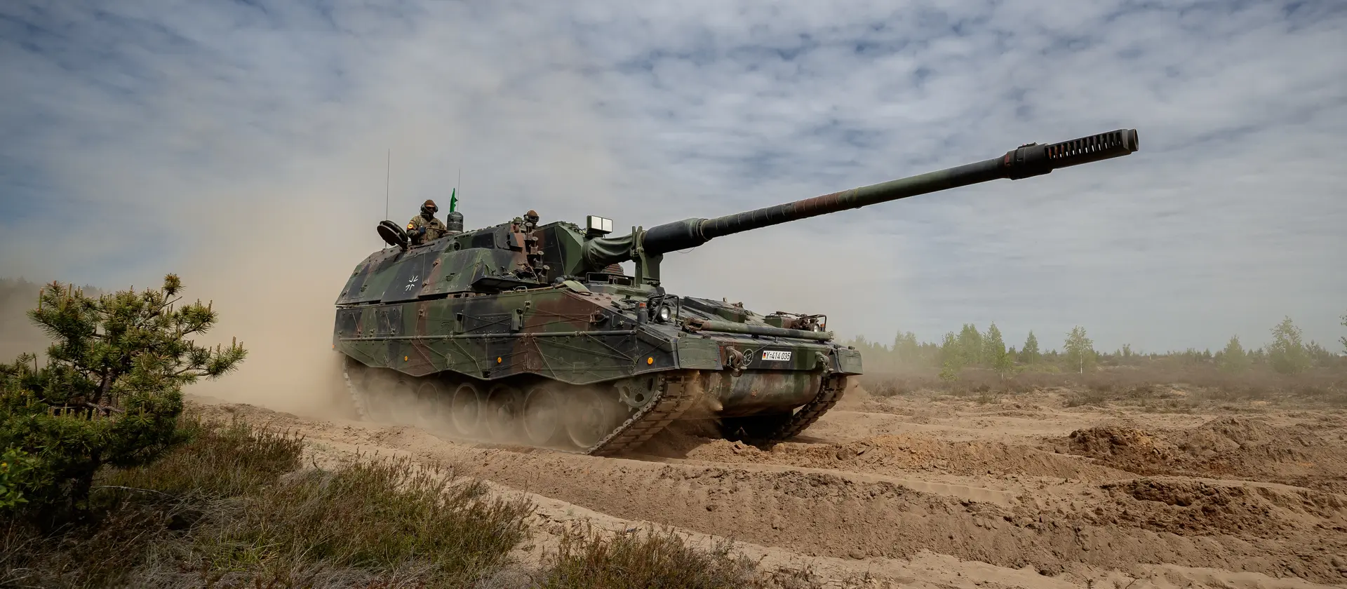 Ein Panzer der Bundeswehr fährt durchs Gelände.