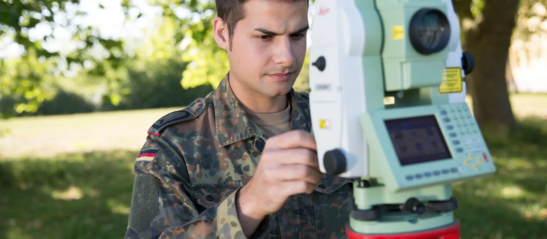 Geoinformationsspezialist in Uniform arbeit an einem technischen Gerät zur Geländebestimmung