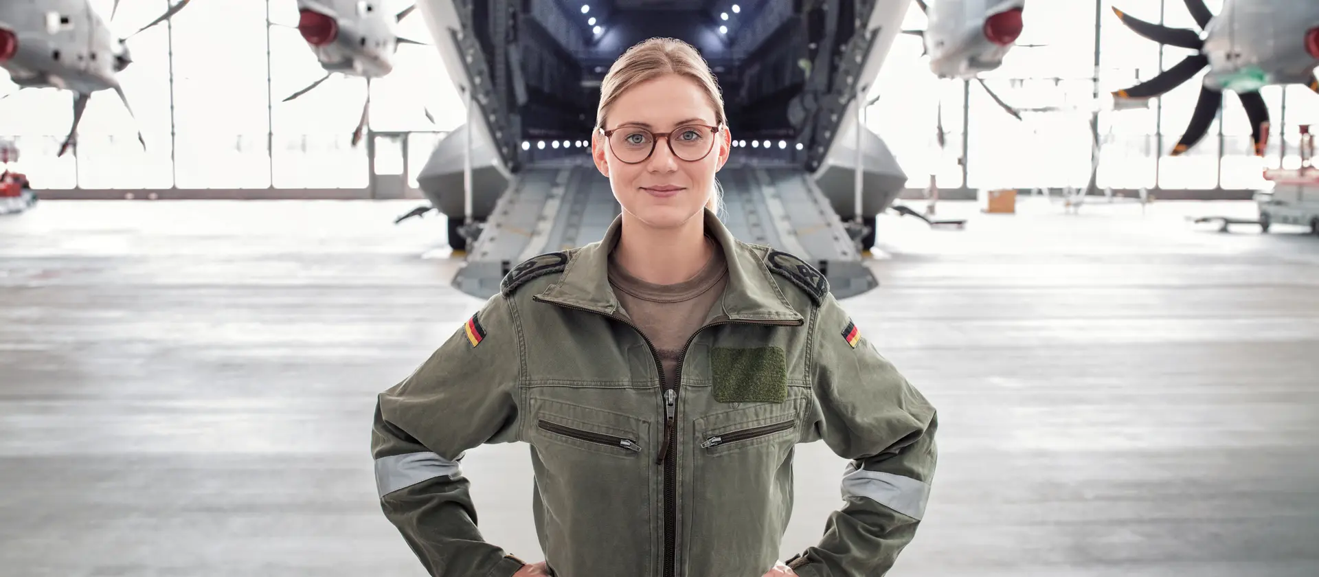 Avionikerin im Bundeswehrkombi vor einem Transportflugzeug A400M