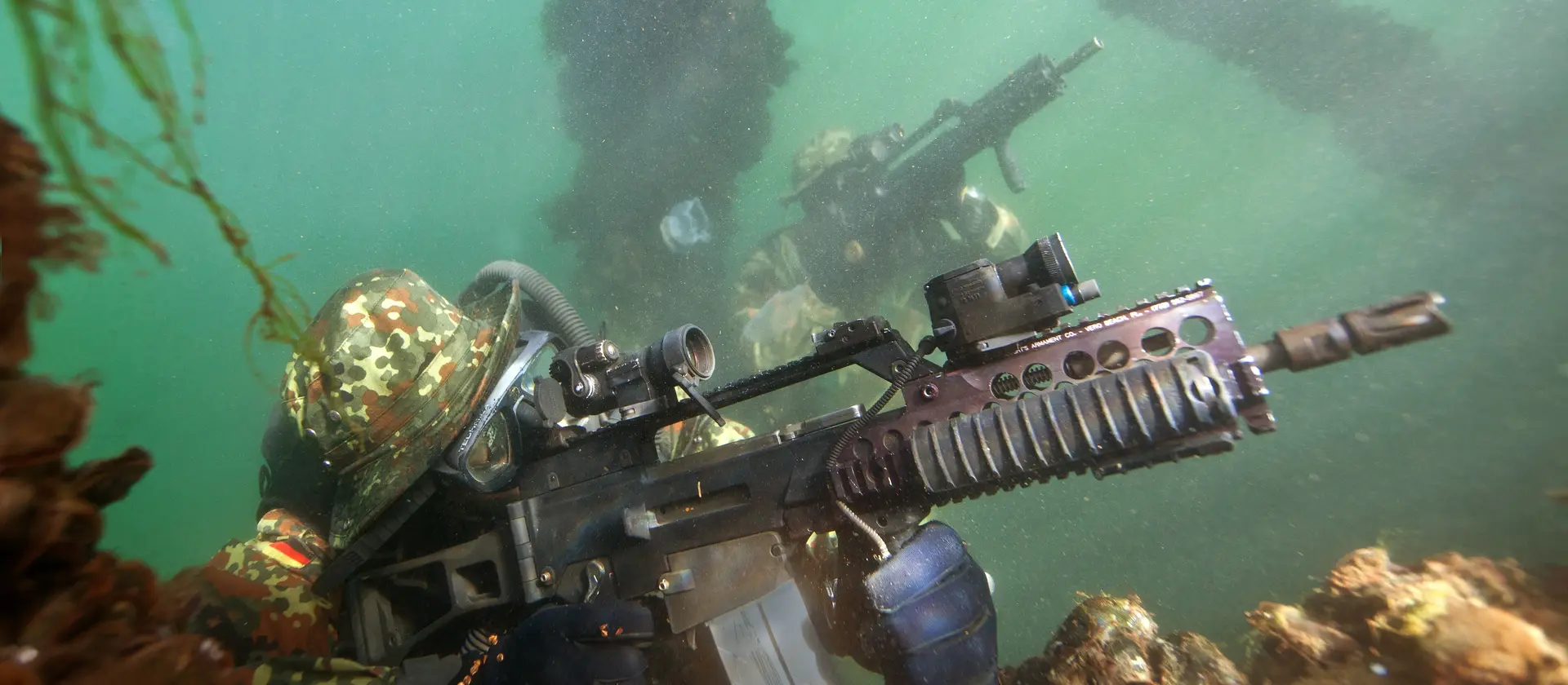 Kampfschwimmer mit Gewehr im Anschlag unter Wasser