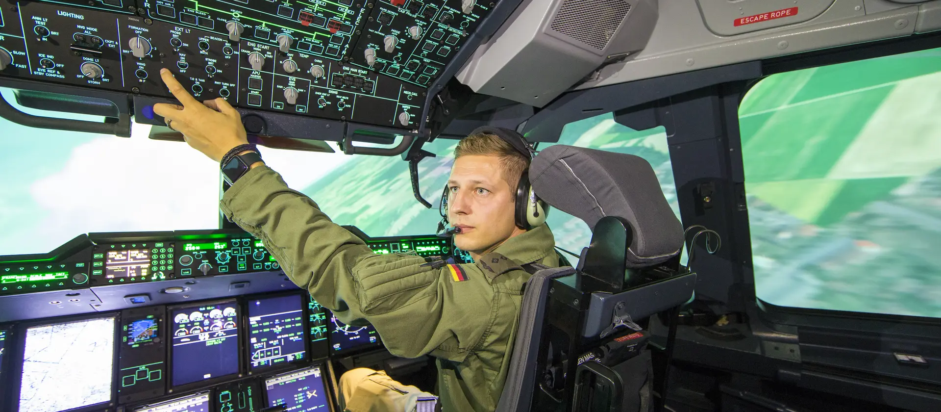 Pilot in Uniform sitzt im Cockpit und überprüft diverse Schalter