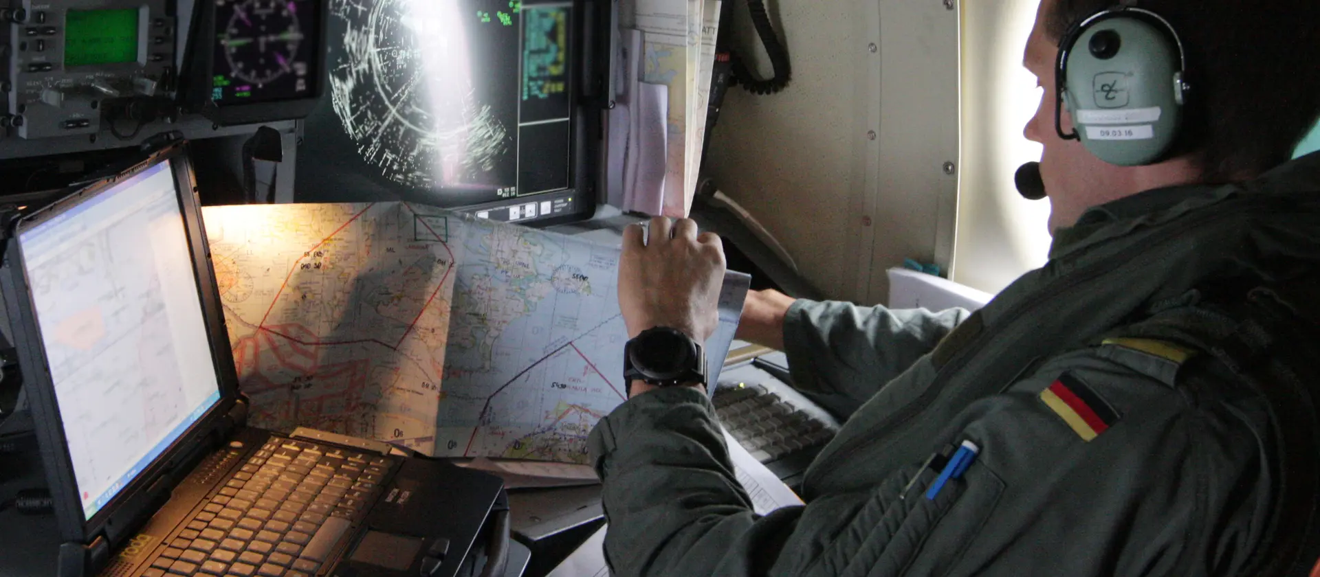 Soldat mit Landkarten sitzt in einem Militärflugzeug