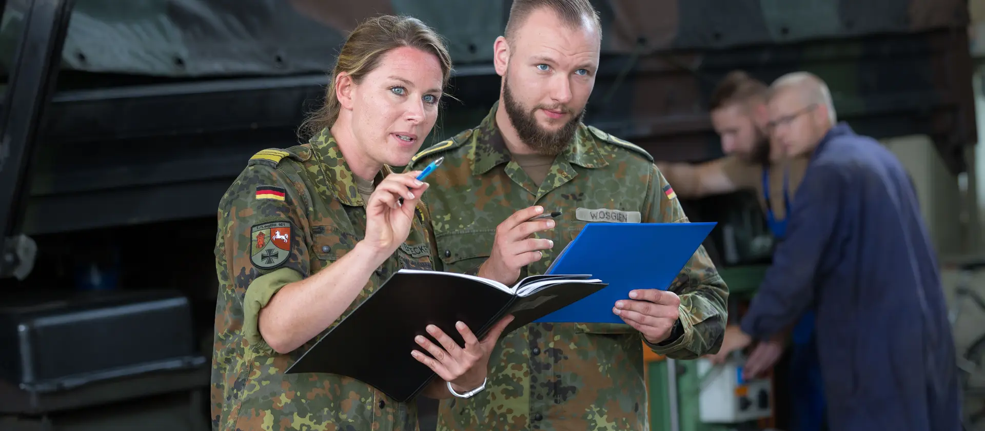 Koordinatorin und Koordinator, beide in Uniform, überprüfen Listen