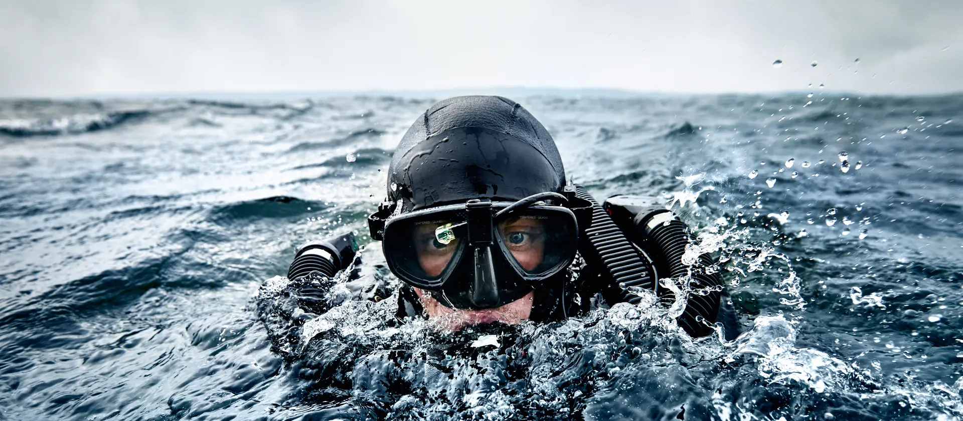Ein Kampfschwimmer taucht aus dem Wasser auf