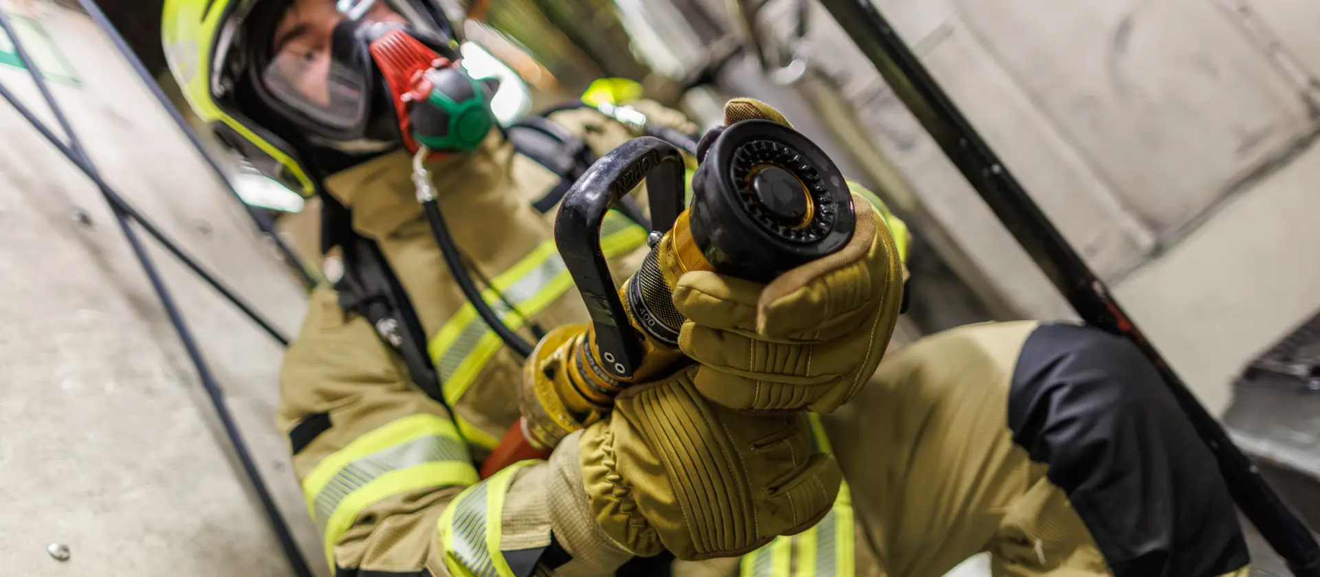 Soldat im Brandschutz mit C-Rohr und voller Ausrüstung