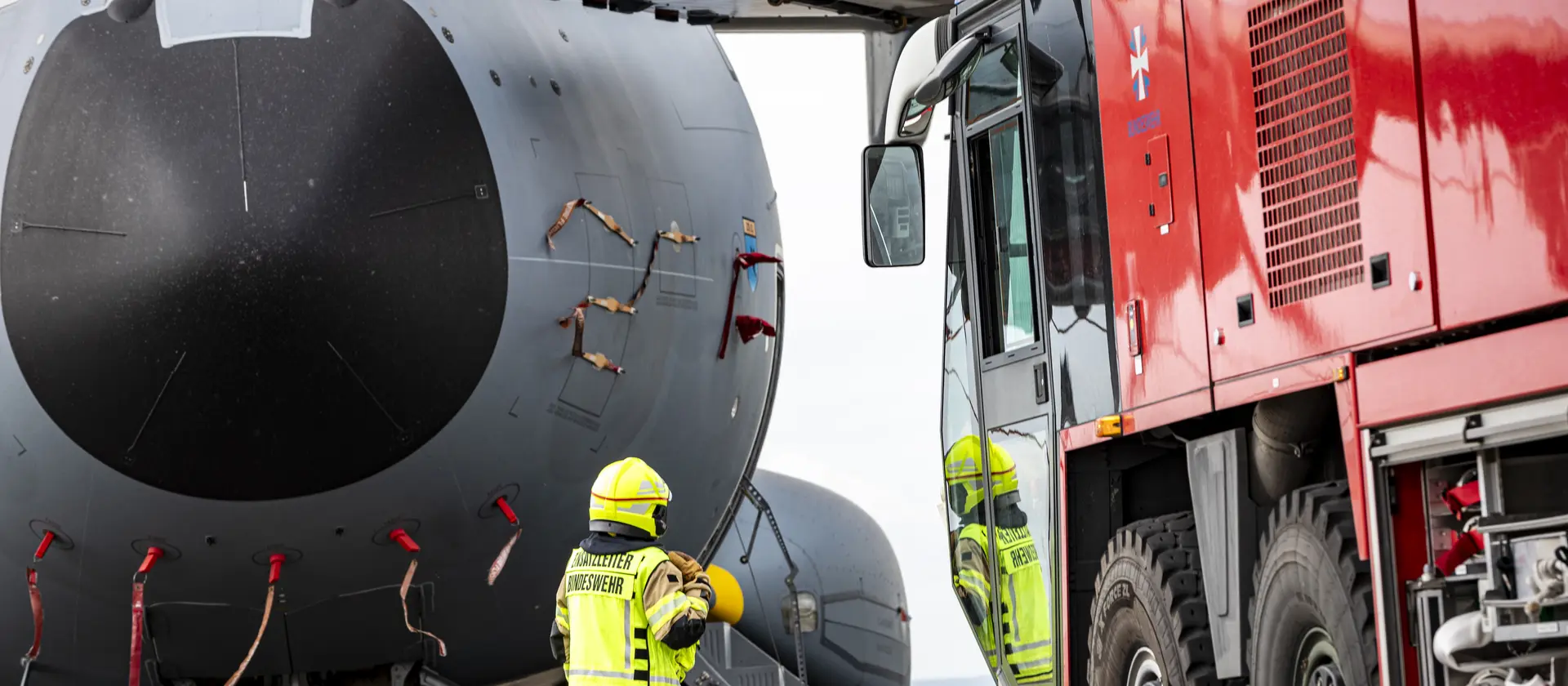 Die Feuerwehr steht neben einem Flugzeug