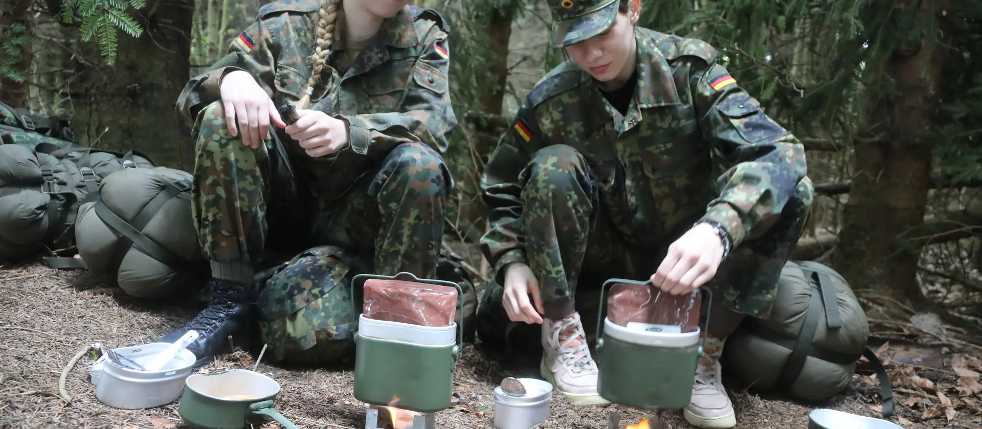 Kameraden im Biwak bereiten Essen vor