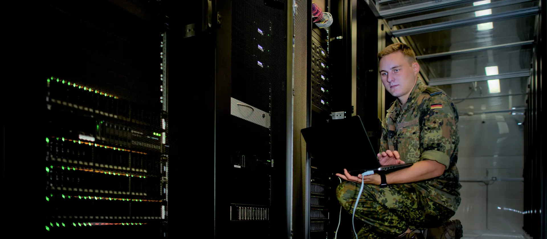 Ein IT Soldat schließt seinen Laptop an einen Server an