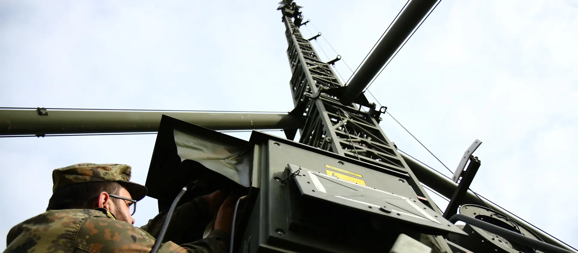 Ein Soldat der Bundeswehr, der an einer Richtfunkanlage arbeitet.