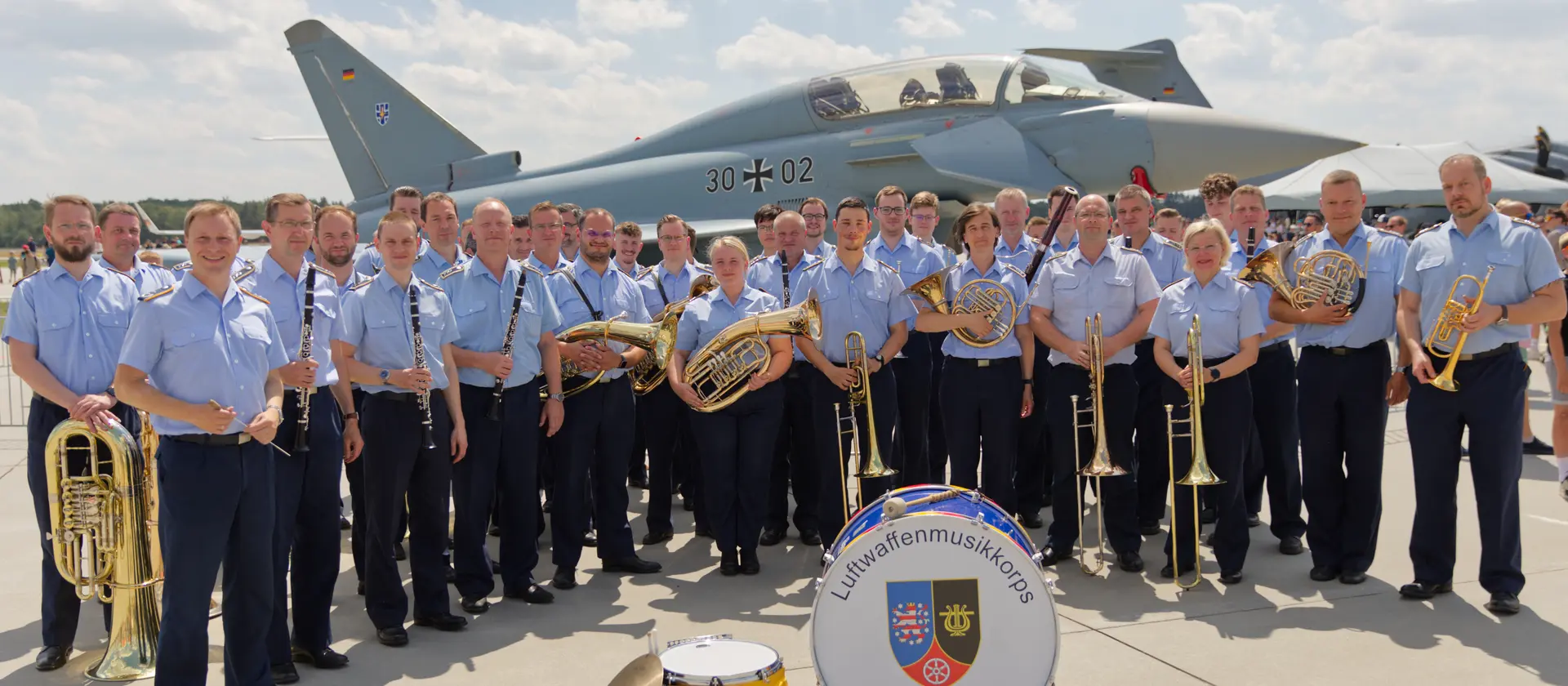 Soldatinnen und Soldaten des Musikkorps stehen vor einem Eurofighter
