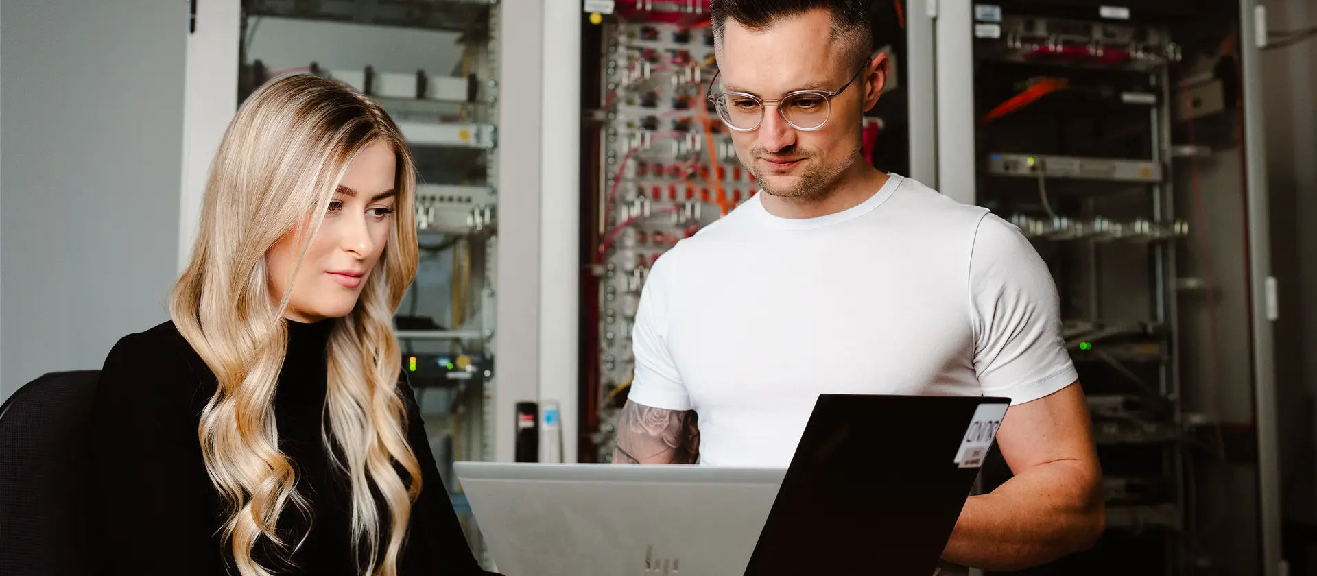 Eine Frau und ein Mann haben jeweils ein Laptop vor sich.
