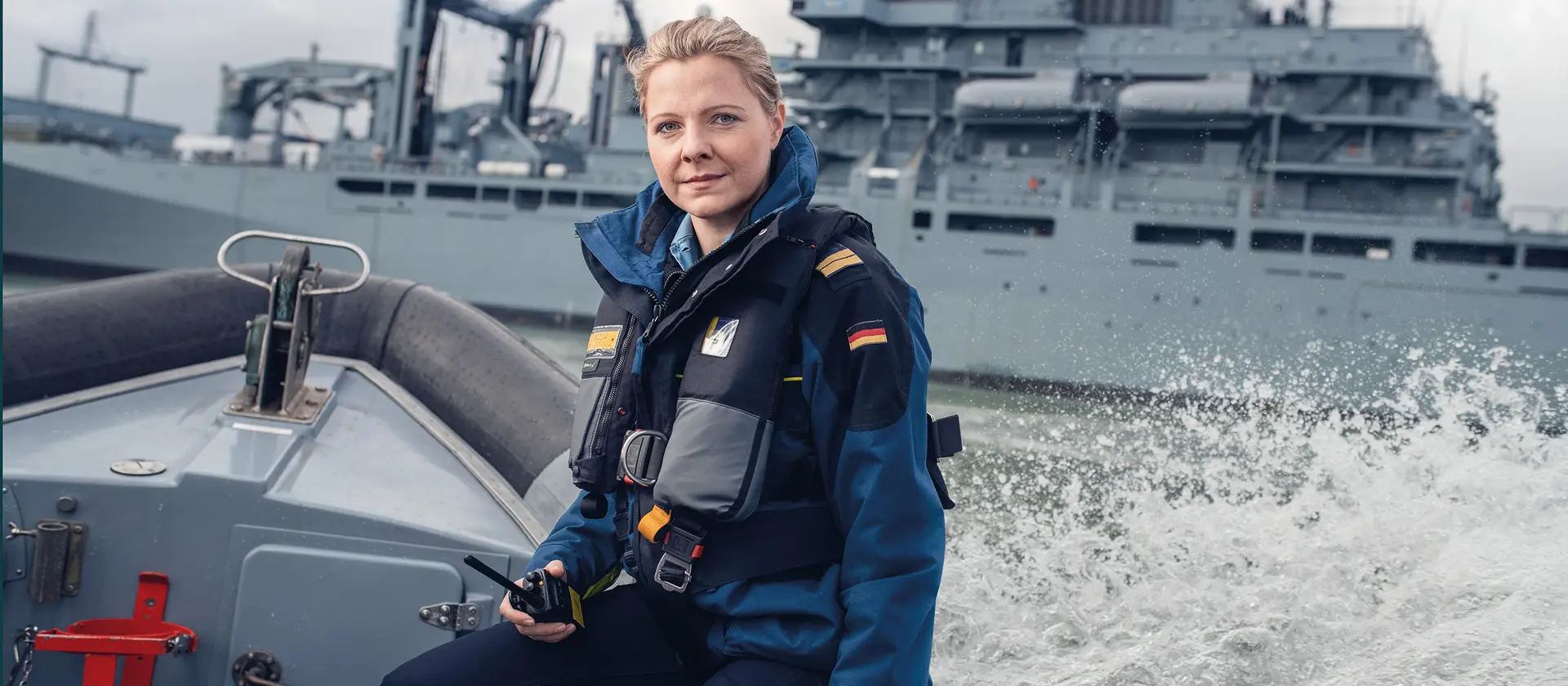 Eine Soldatin sitzt auf dem Rand eines Bootes