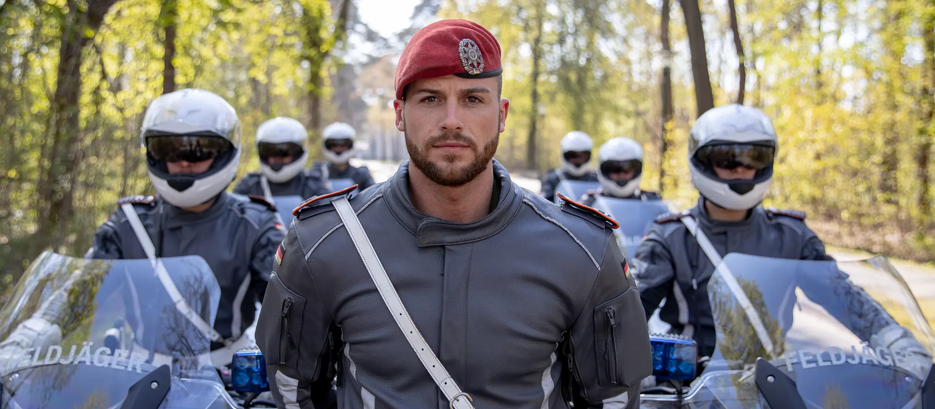 Ein Soldat der Feldjägertruppe steht im Motorradkombi vor der Motorradeskorte.