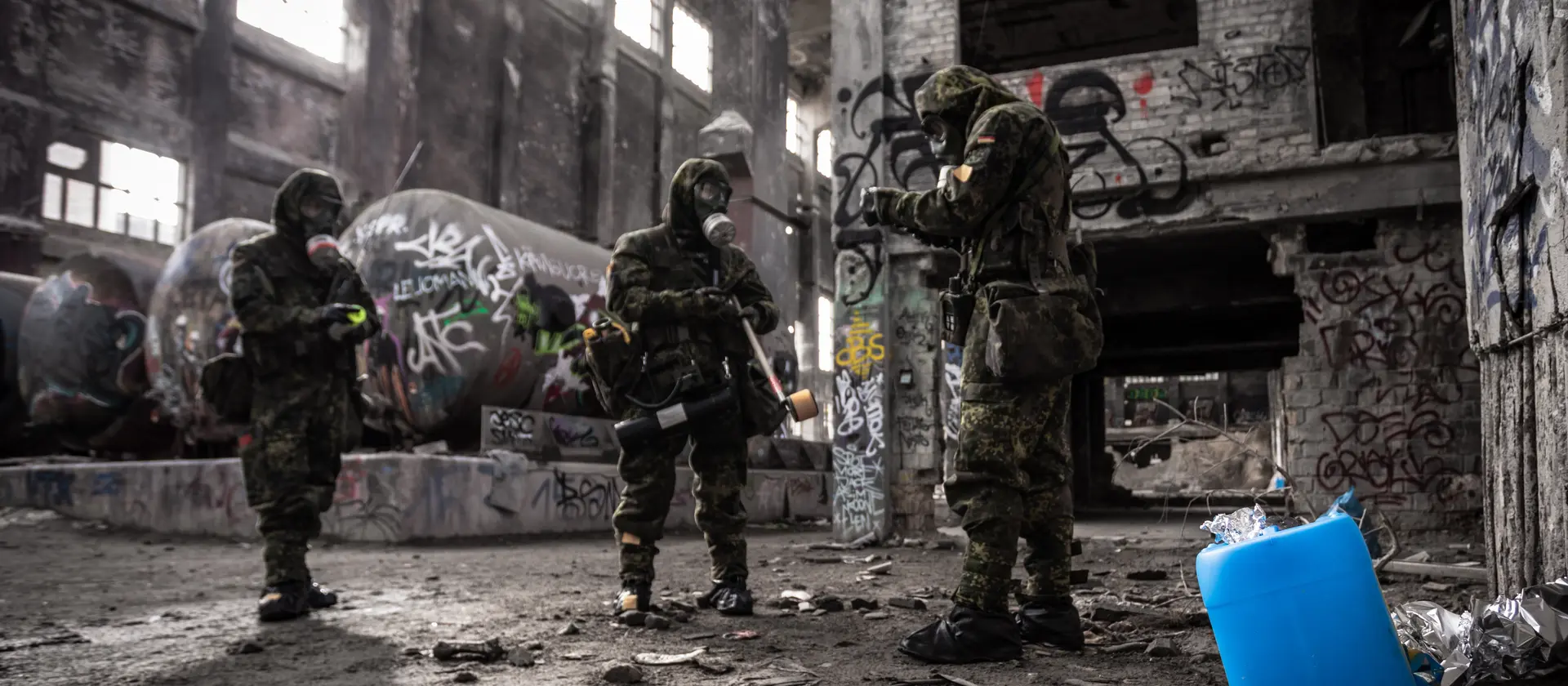 Soldaten der ABC Abwehrtruppe mit Schutzmasken untersuchen eine Lagerhalle auf Kampfstoffe.