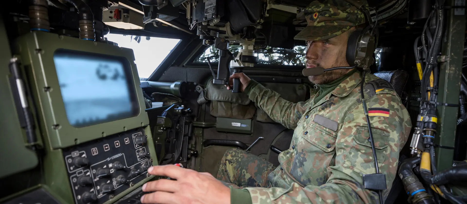 Ein Soldat der Heeresaufklärungstruppe sitzt in einem gepanzerten Fahrzeug und bedient technisches Gerät.