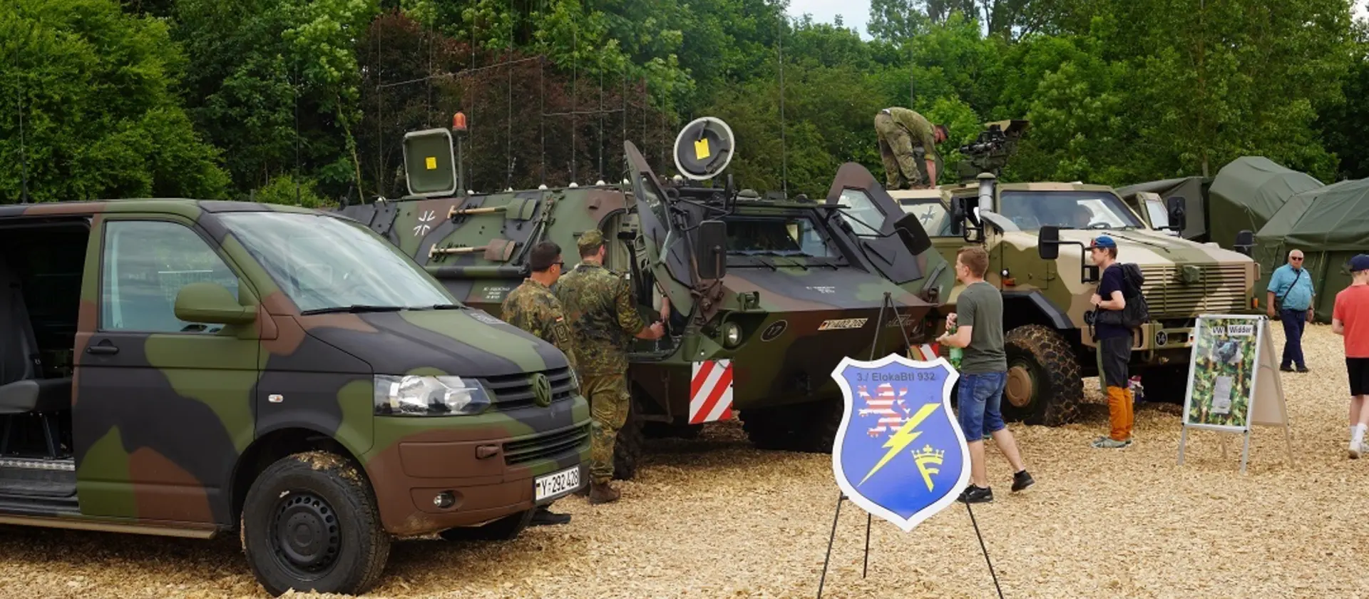 Die Bundeswehr steht mit Fahrzeugen und Soldatinnen und Soldaten auf einem Feld