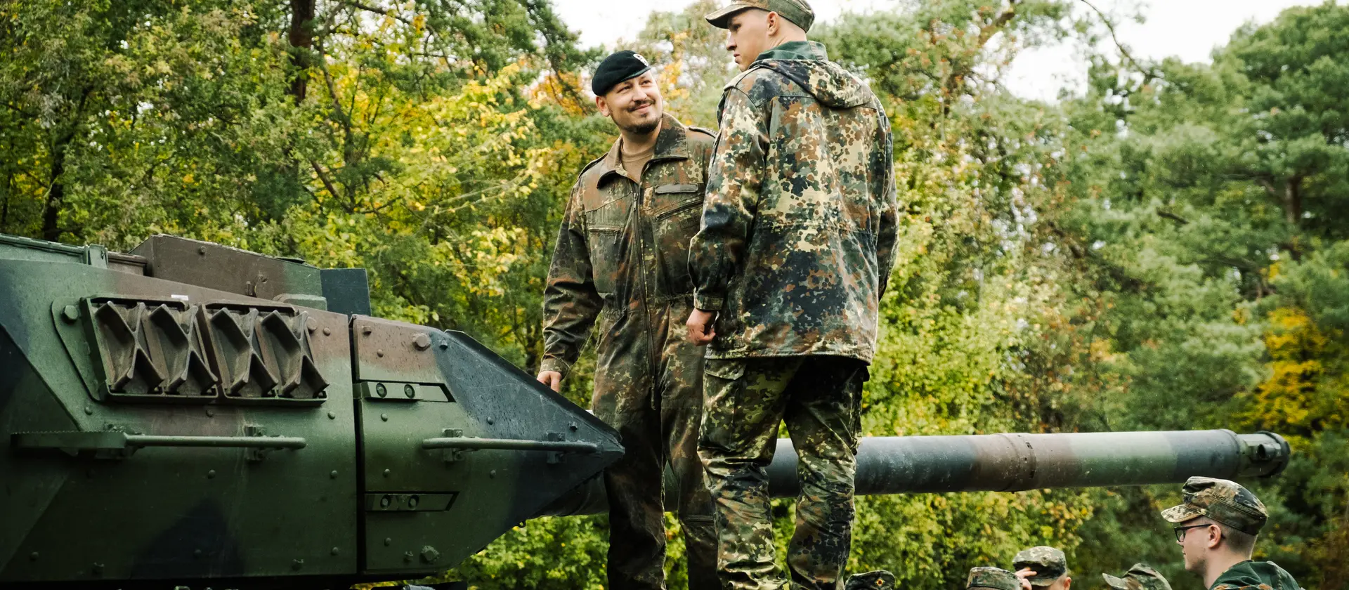 Zwei Soldaten stehen auf einem Panzer