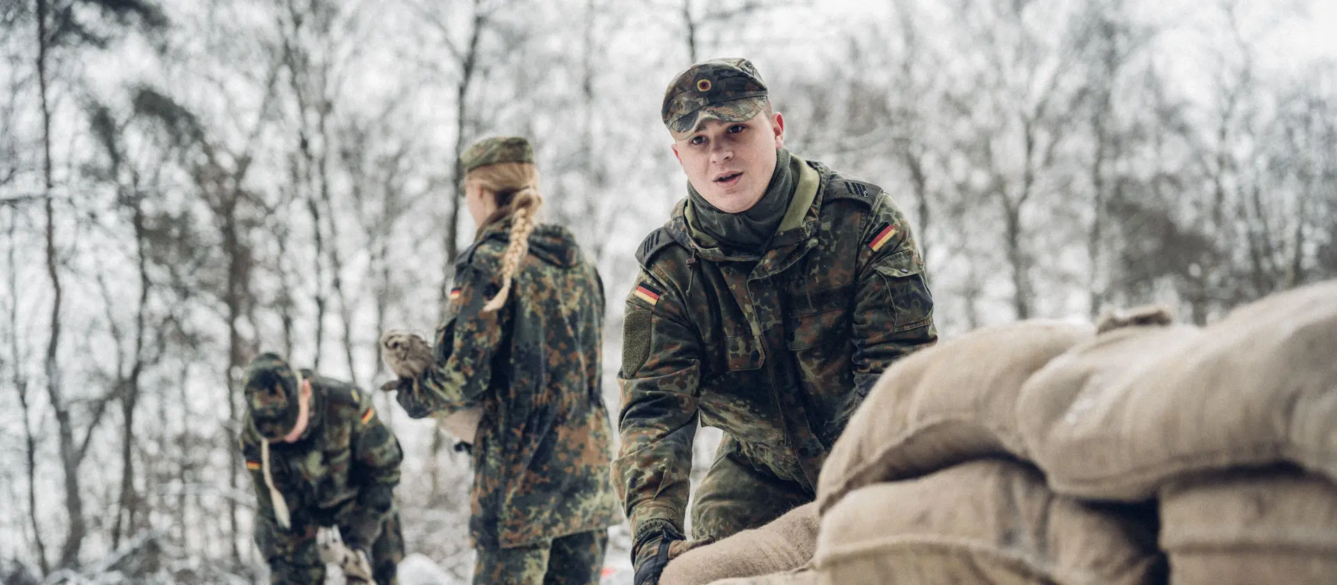 Soldaten in Tarnkleidung stapeln Sandsäcke