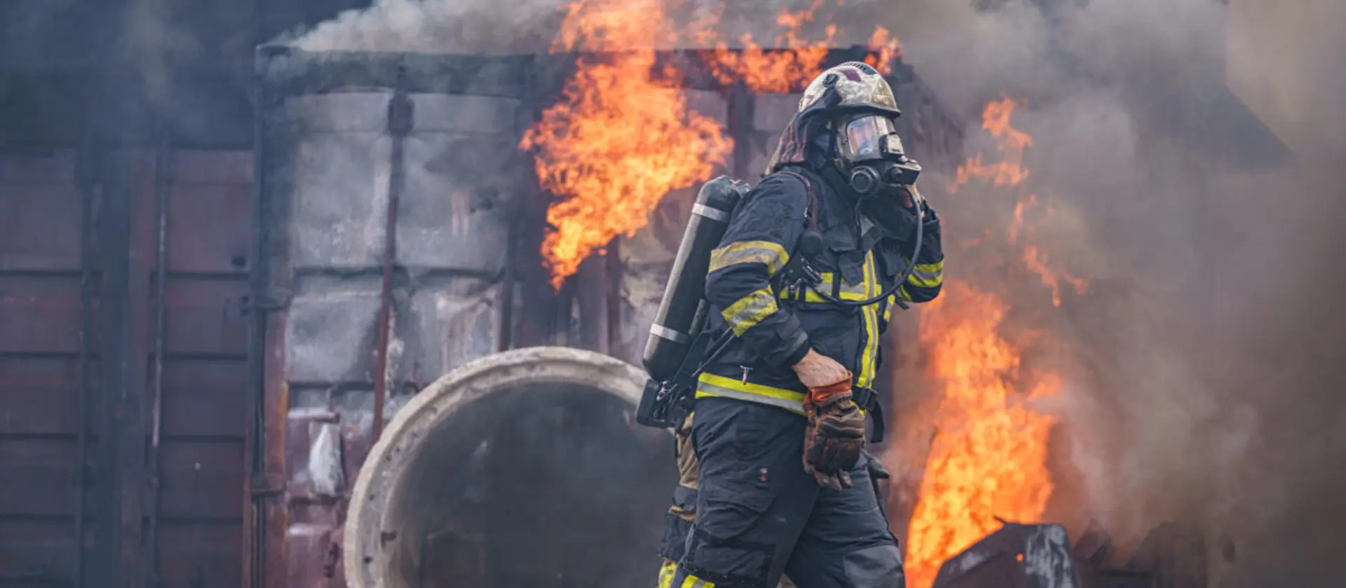 Feuerwehmänner gehen an einem Brand vorbei