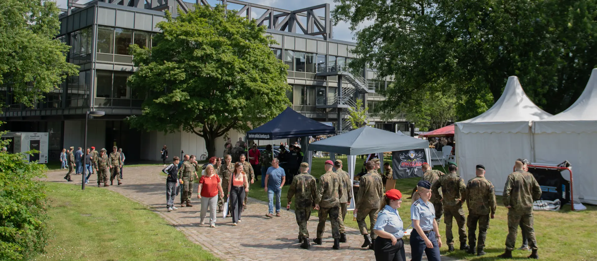 Soldatinnen und Soldaten stehen bei einem Event vor einem Gebäude