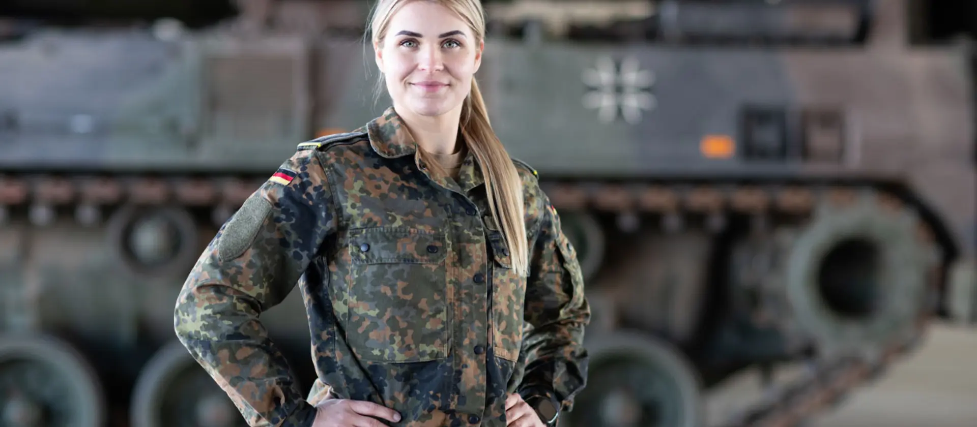 Eine Soldatin der Bundeswehr steht vor einem Panzer