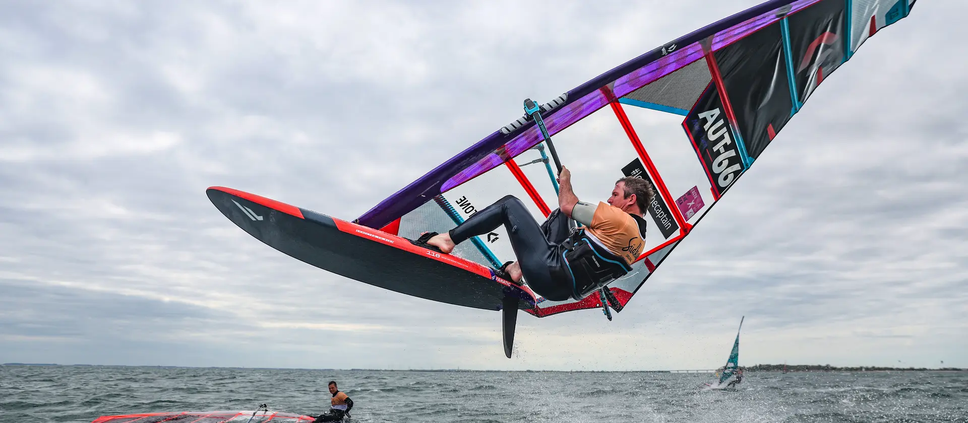 Ein Windsurfer springt mit der Surfboard