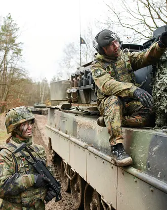 Zwei Soldaten in Tarnkleidung an einem Bundeswehrfahrzeug