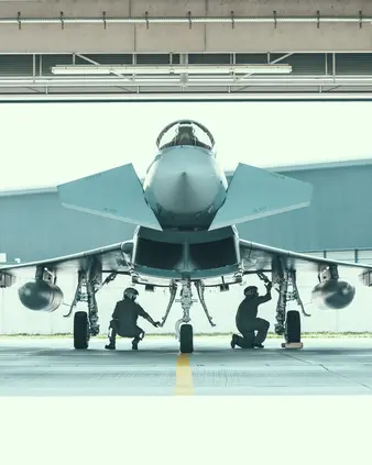Zwei Personen inspizieren ein Flugzeug, das in einem Hangar steht