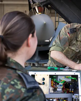 Eine Soldatin und ein Soldat reparieren ein technisches Gerät