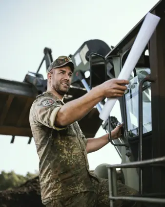 Ein Soldat neben einem Bundeswehrfahrzeug