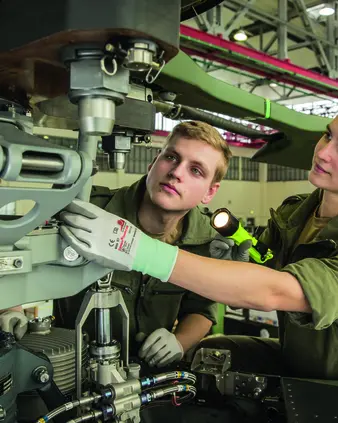 Eine Soldatin und ein Soldat bei der Reparatur eines Fahrzeugs